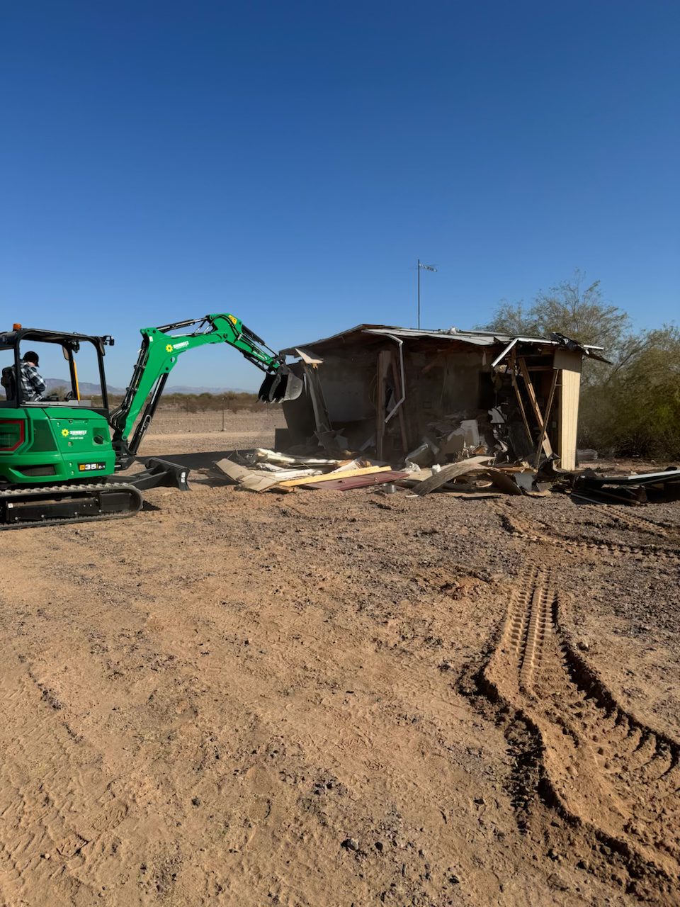 Excavator demolishing an old structure on purchased land